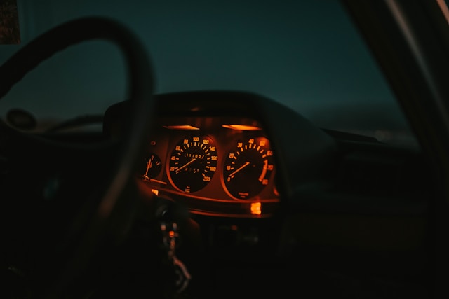 Habitacle de BMW E30 avec tableau de bord orienté vers le conducteur, sièges sport et instrumentation typique des BMW des années 80.