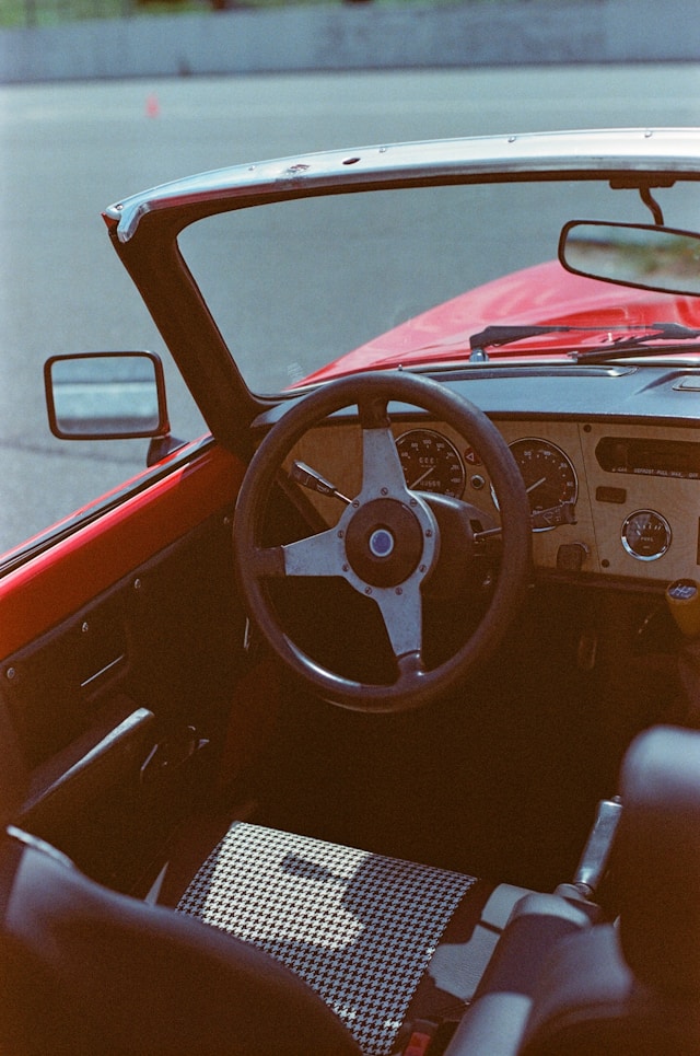 Cockpit d’une Triumph Spitfire avec volant bois et instrumentation classique des roadsters anglais.