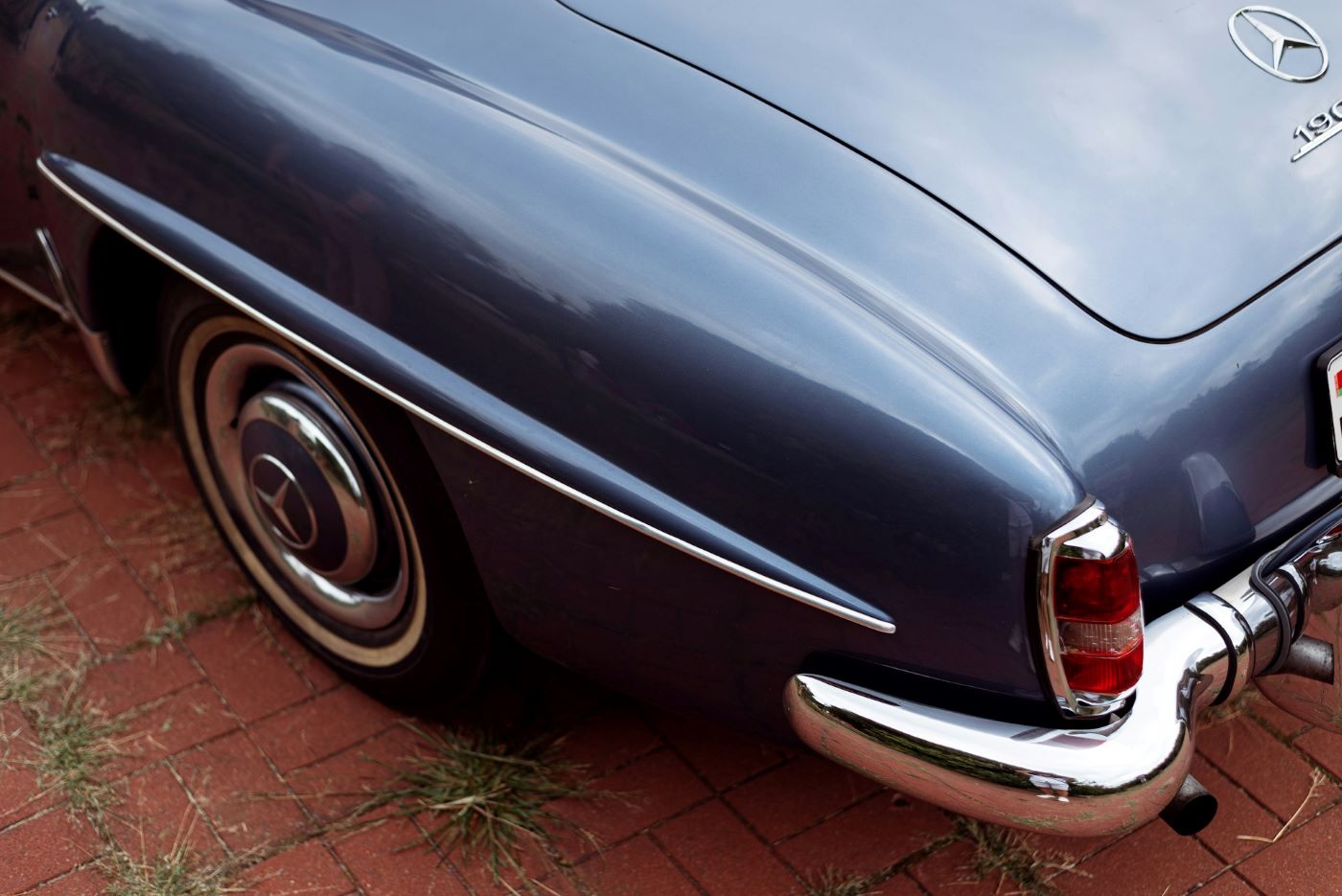 Gros plan sur l'arrière d'une Mercedes 190 SL, soulignant la qualité de fabrication et les finitions caractéristiques du roadster Mercedes.