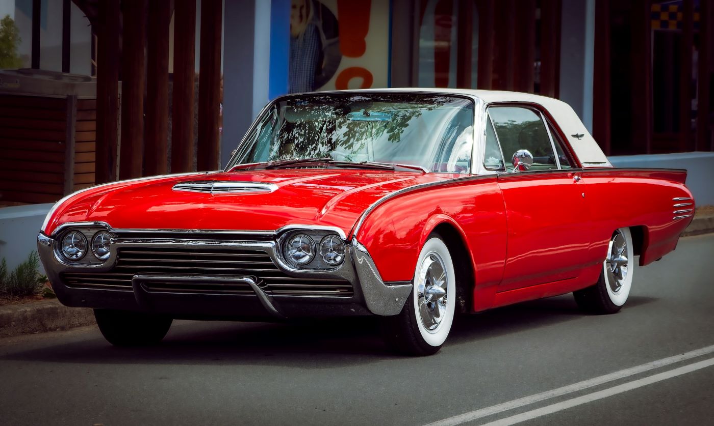 Ford Thunderbird des années 1970 de couleur sombre stationnée en extérieur, illustration du style luxueux et imposant des grandes américaines de collection.