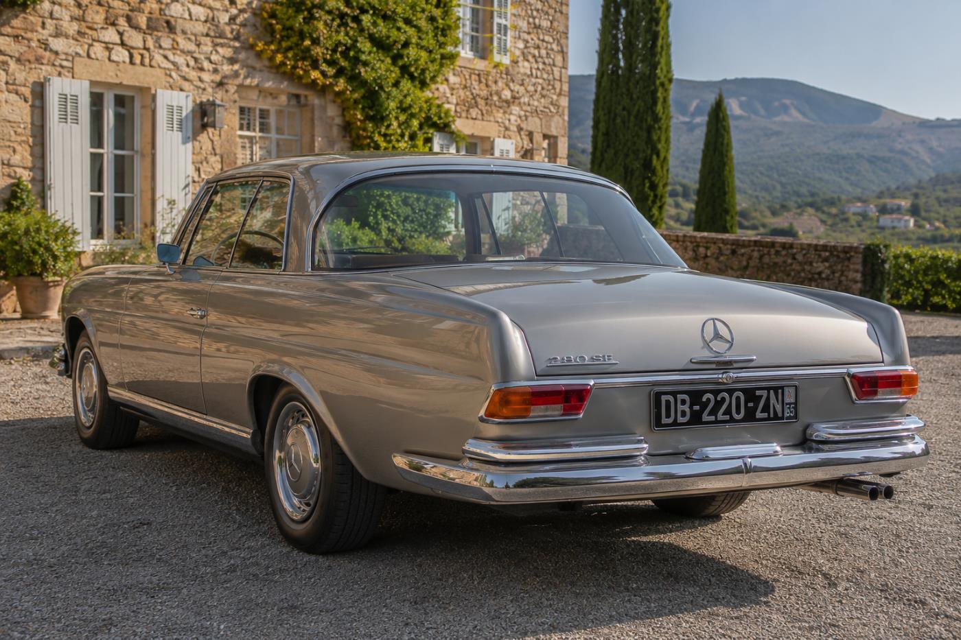 Mercedes W111 Coupé vue de trois-quarts arrière révélant sa carrosserie sans montant central et ses lignes élégantes.