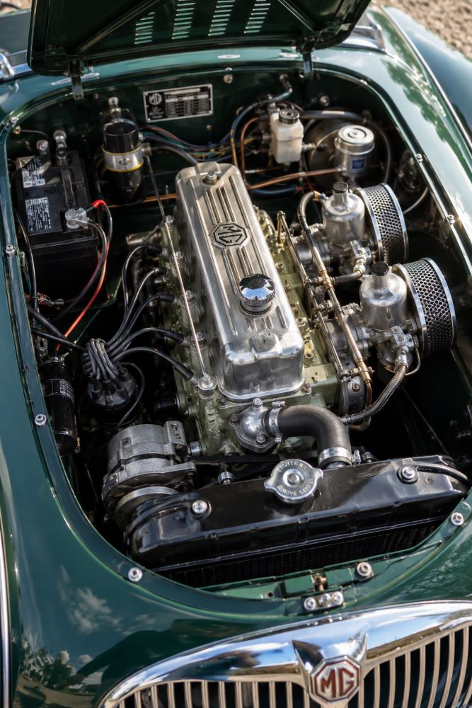 Moteur quatre cylindres B-Series d'une MGA avec capot ouvert, mettant en valeur la mécanique simple et robuste du roadster britannique.