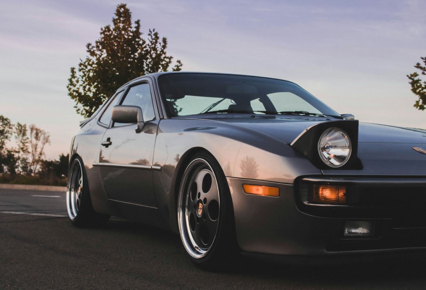 Porsche 944 de collection avec phares escamotables relevés, détail emblématique des sportives Porsche des années 1980.