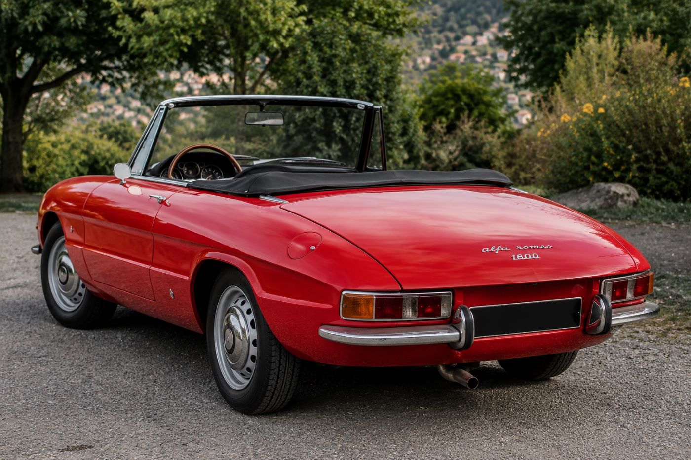 Alfa Romeo Spider Duetto rouge vue de trois quarts arrière, mettant en valeur l'élégance de la poupe et les proportions du célèbre cabriolet italien.