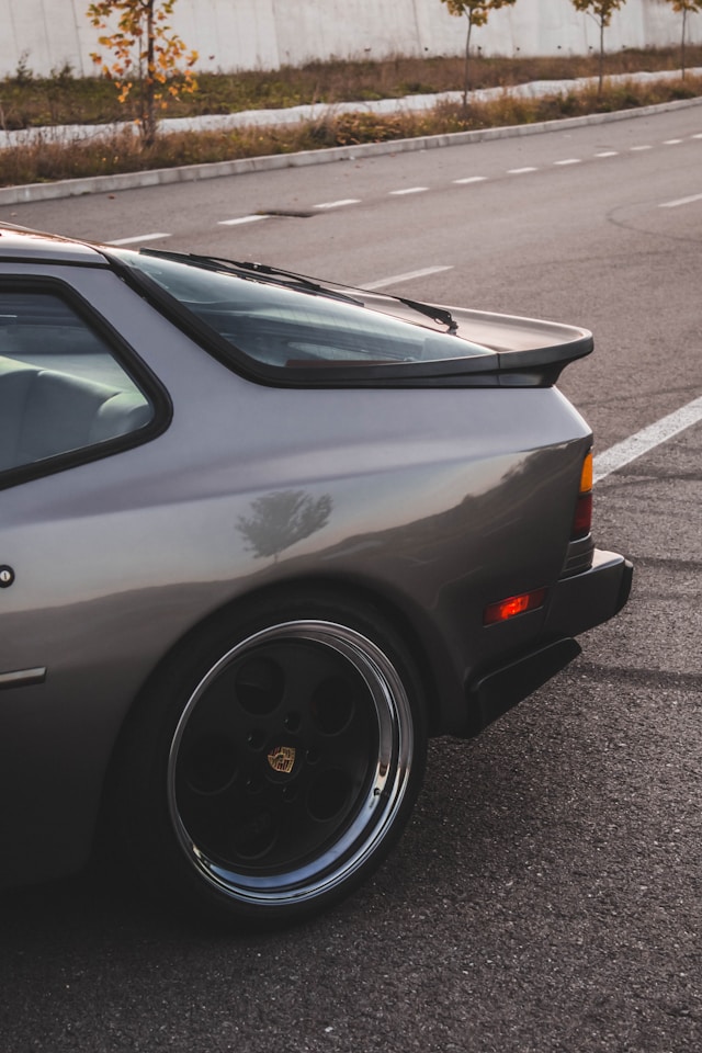 Vue arrière d'une Porsche 944 de collection mettant en valeur son large hayon vitré et sa silhouette caractéristique.