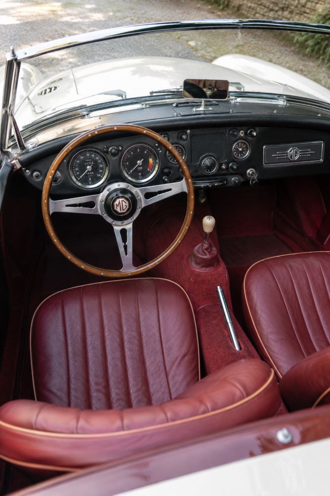 Habitacle d'une MGA avec volant d'origine, compteurs Smiths et tableau de bord typique des roadsters britanniques des années 1950.