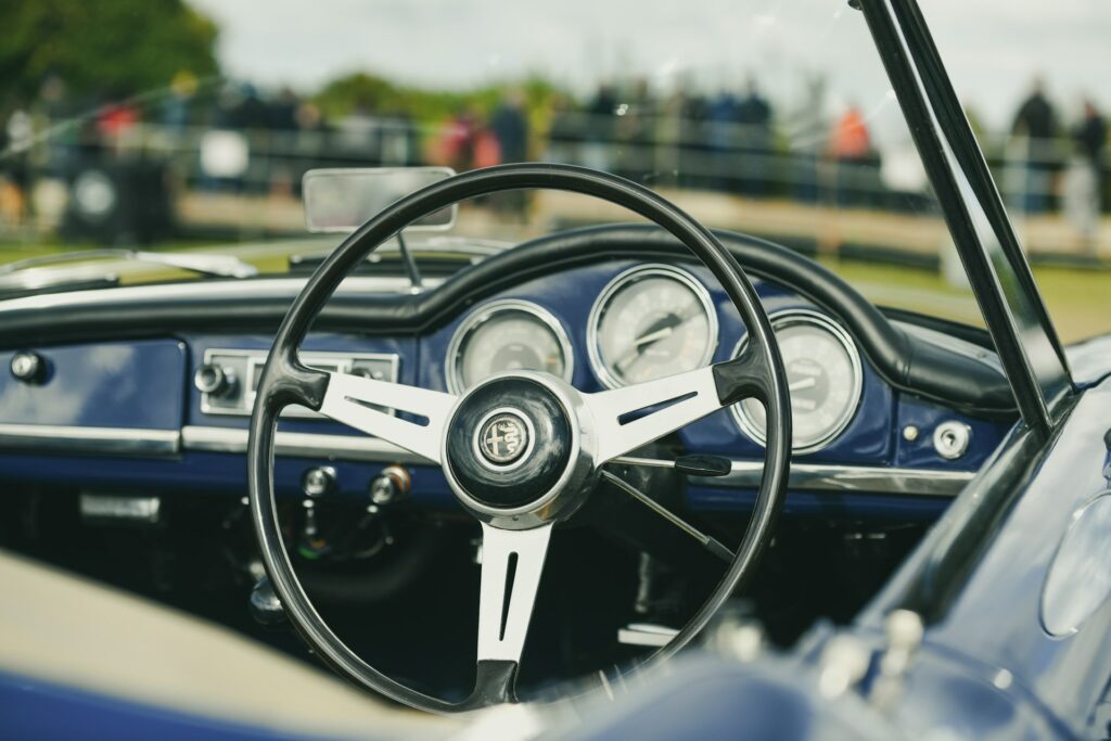 Habitacle d'Alfa Romeo Giulietta de collection avec instrumentation Veglia, volant d'origine et ambiance sportive typique des Alfa Romeo classiques.