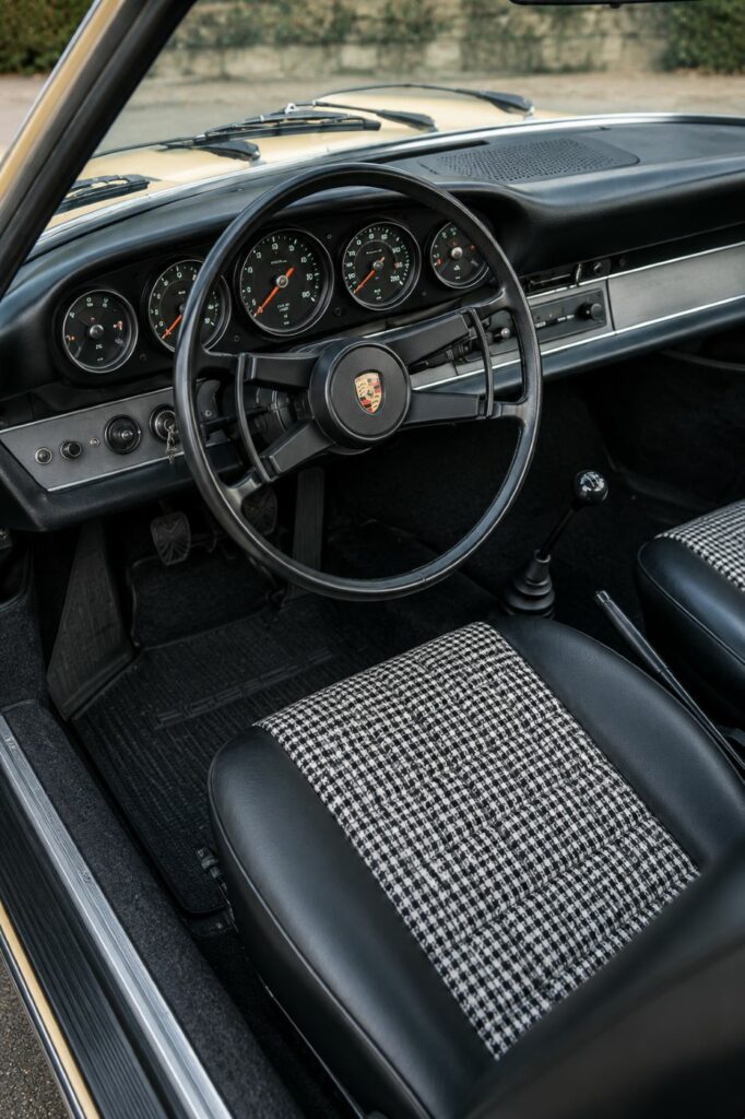 Habitacle d'une Porsche 912 avec tableau de bord à cinq compteurs, volant d'origine et intérieur typique des Porsche classiques des années 1960.
