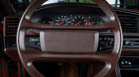 Habitacle de Porsche 944 avec tableau de bord orienté vers le conducteur, instrumentation complète et ambiance typique des sportives Porsche des années 1980.