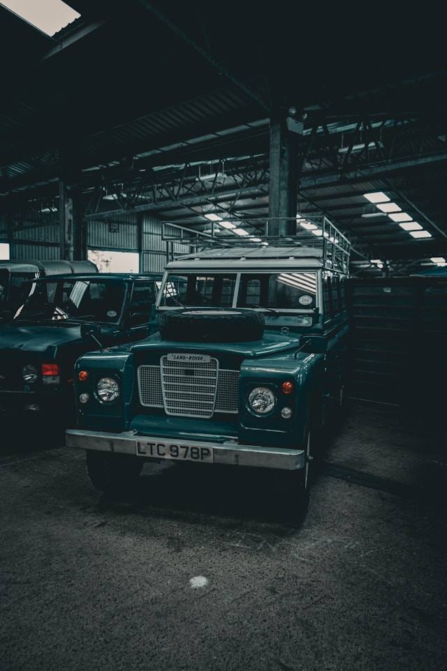 Land Rover Série de collection en cours d'entretien dans un garage spécialisé, mettant en avant la simplicité de sa mécanique.