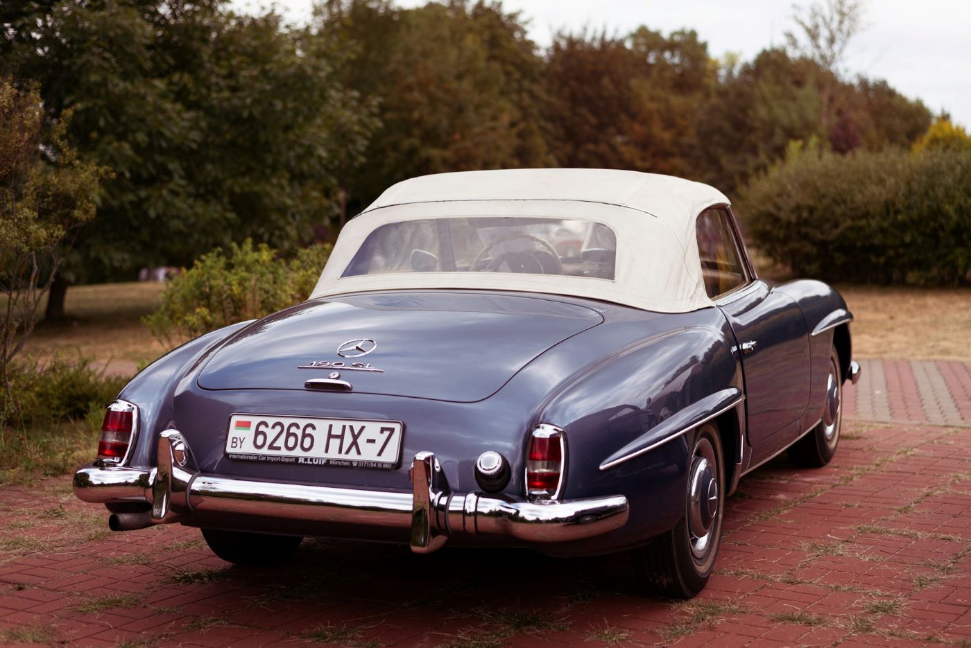 Mercedes 190 SL vue arrière avec capote fermée, mettant en valeur les lignes harmonieuses et le design intemporel du célèbre roadster allemand.