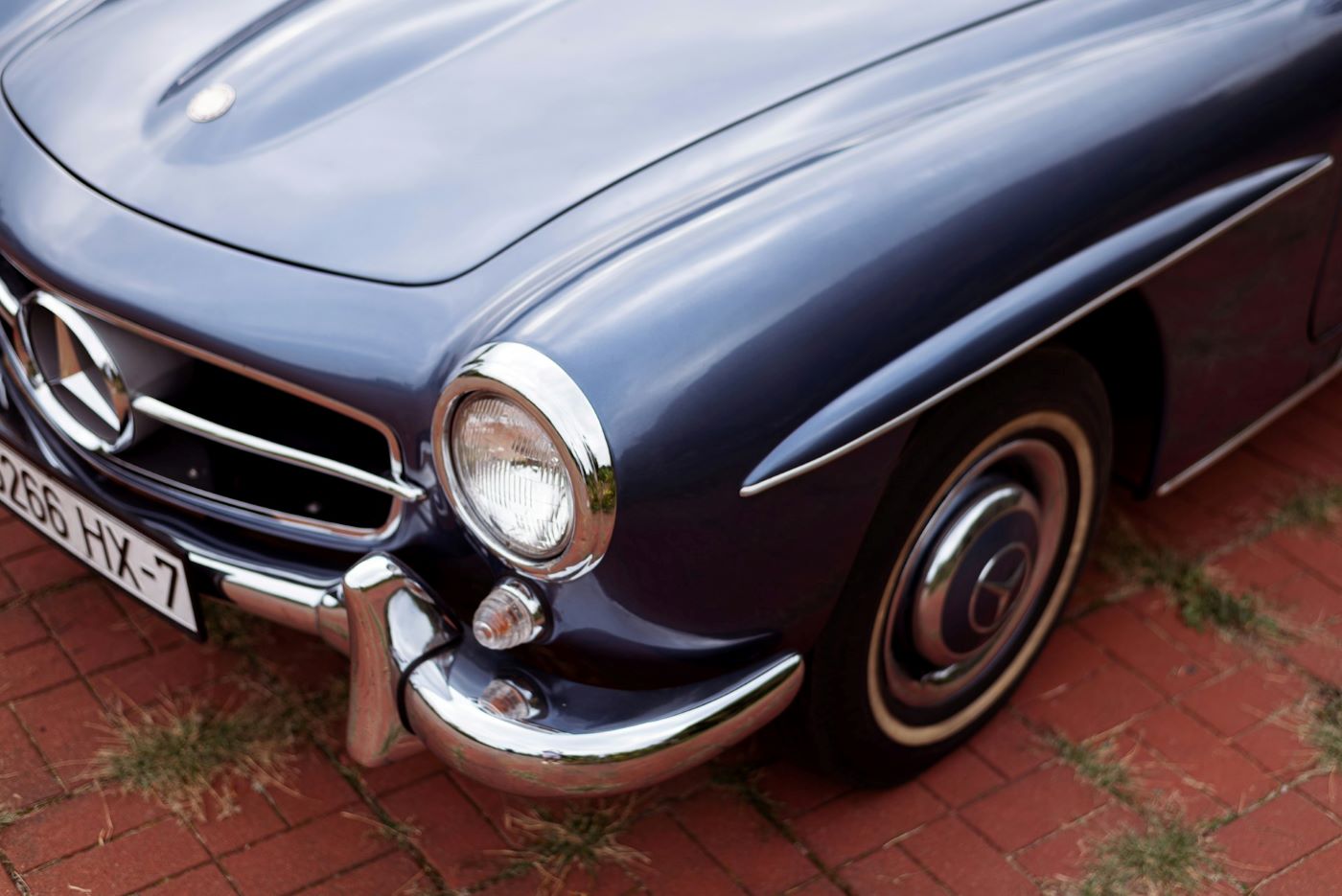 Détail de la face avant d'une Mercedes 190 SL de collection, mettant en valeur les chromes et les éléments distinctifs du modèle.