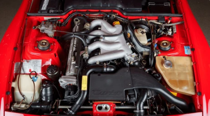 Moteur quatre cylindres Porsche 944 avec ses éléments de distribution et son architecture caractéristique, point essentiel à contrôler avant achat.