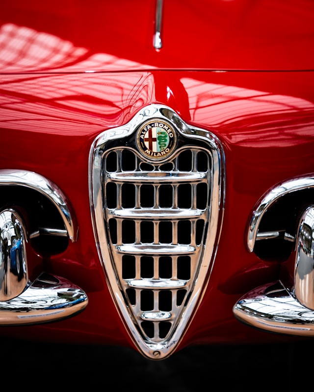 Calandre emblématique d'une Alfa Romeo Giulietta de collection avec le célèbre écusson Alfa Romeo et les prises d'air caractéristiques des années 1950.