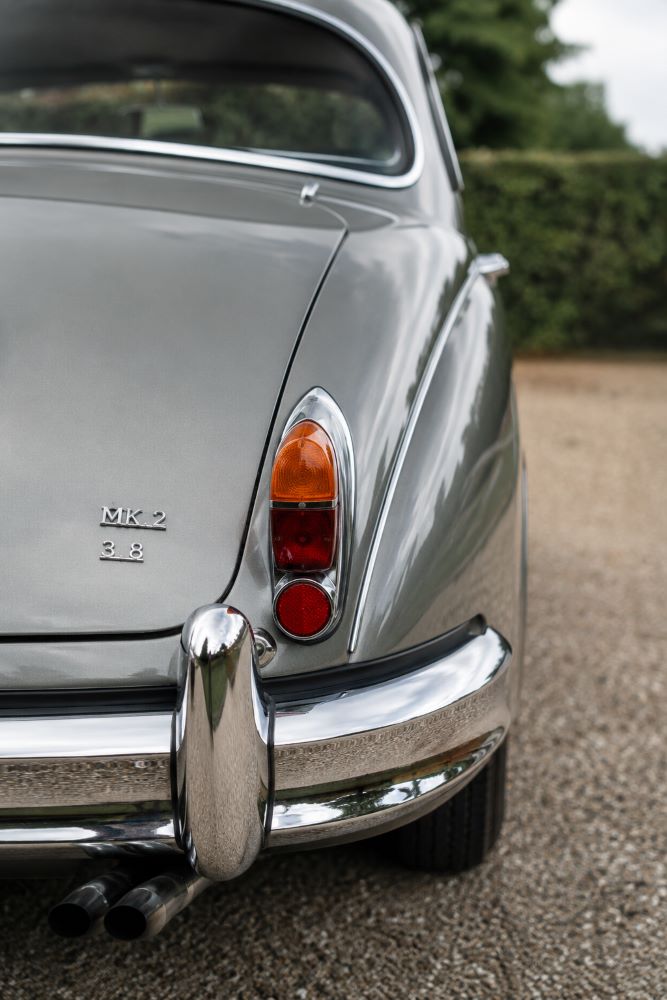 Zoom sur le feu arrière droit et les chromes d'une Jaguar MK2 mettant en valeur les détails caractéristiques de son design des années 1960.