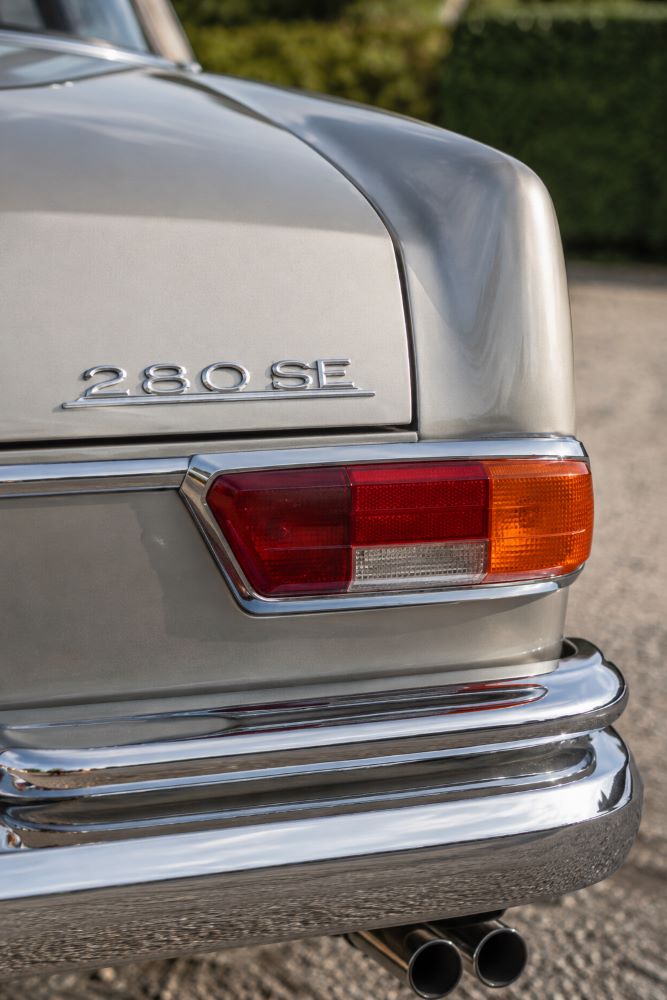 Zoom sur le feu arrière droit et les chromes d'une Mercedes W111 Coupé mettant en valeur les détails caractéristiques de ce coupé Mercedes des années 1960.