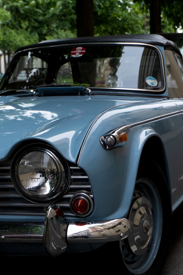 Triumph TR4 rouge vue trois quarts avant, design signé Michelotti, l'un des roadsters britanniques les plus emblématiques des années 1960.