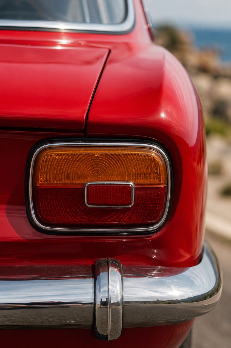 Gros plan sur le feu arrière chromé d'un coupé Alfa Romeo Bertone illustrant la finition classique.