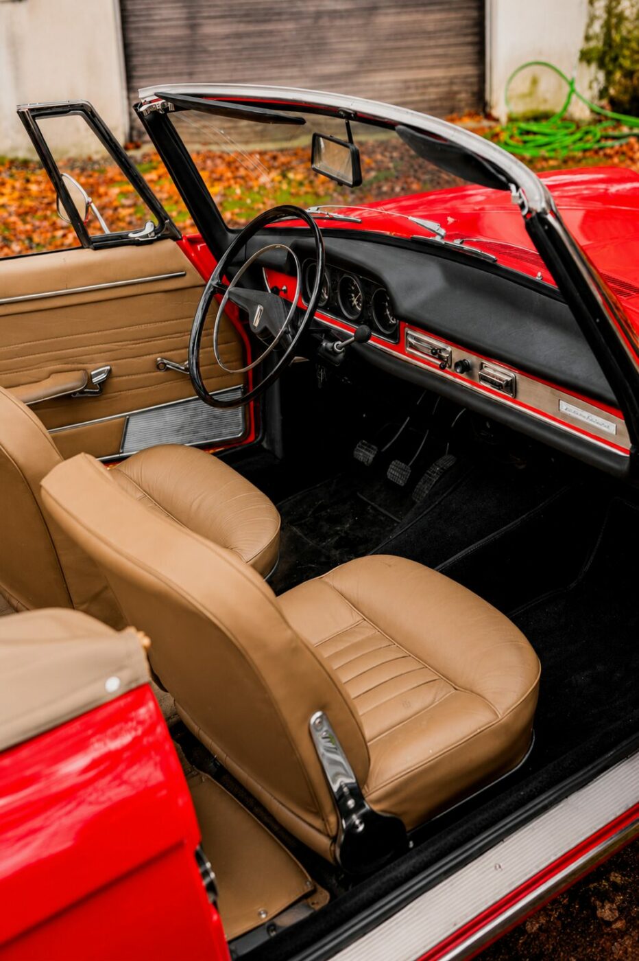 Vue intérieure détaillée de la planche de bord et des sièges en cuir d'un Peugeot 404 cabriolet.