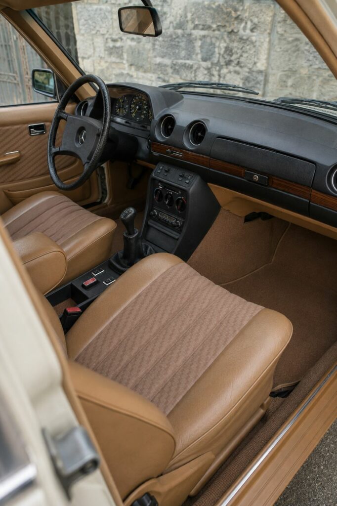 Habitacle d'origine d'une Mercedes W123 avec sellerie beige et inserts en bois