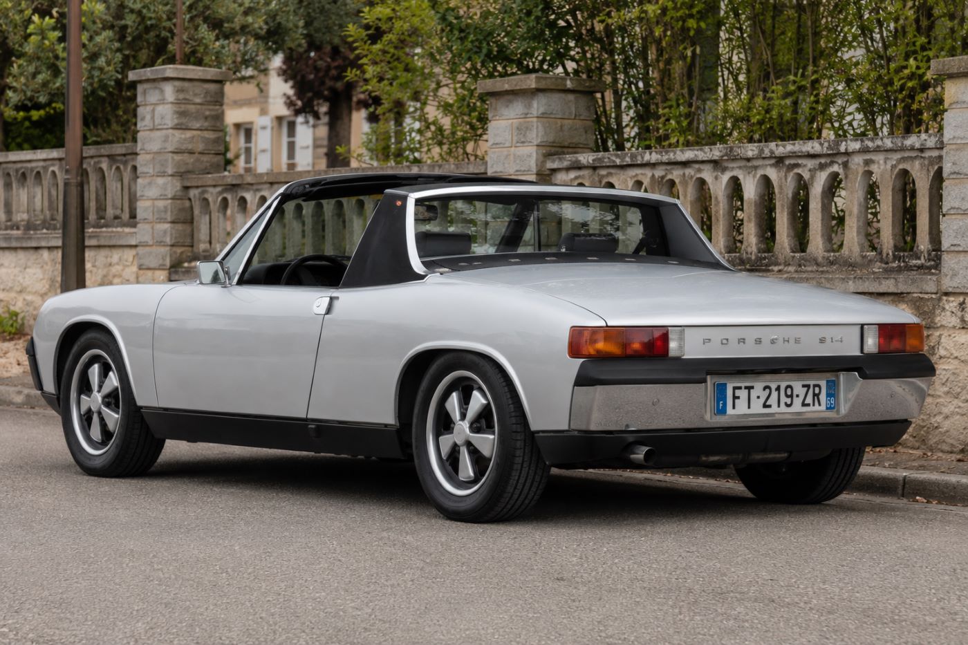 Arrière d'une Porsche 914 de collection, soulignant la poupe caractéristique, les feux arrière et les lignes anguleuses emblématiques des années 1970.