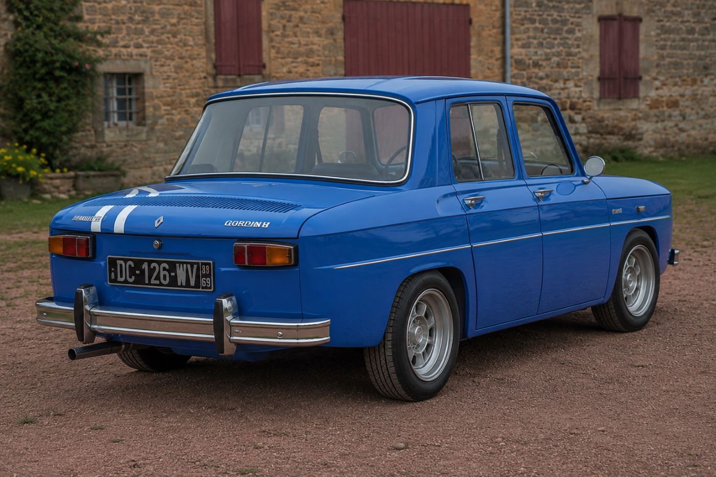 Renault 8 Gordini vue trois-quarts arrière mettant en valeur les bandes blanches, les feux arrière et la silhouette emblématique.