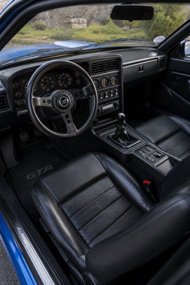 Habitacle d’origine d’une Renault Alpine GTA avec tableau de bord typique des années 1980, instrumentation complète et sièges sportifs.