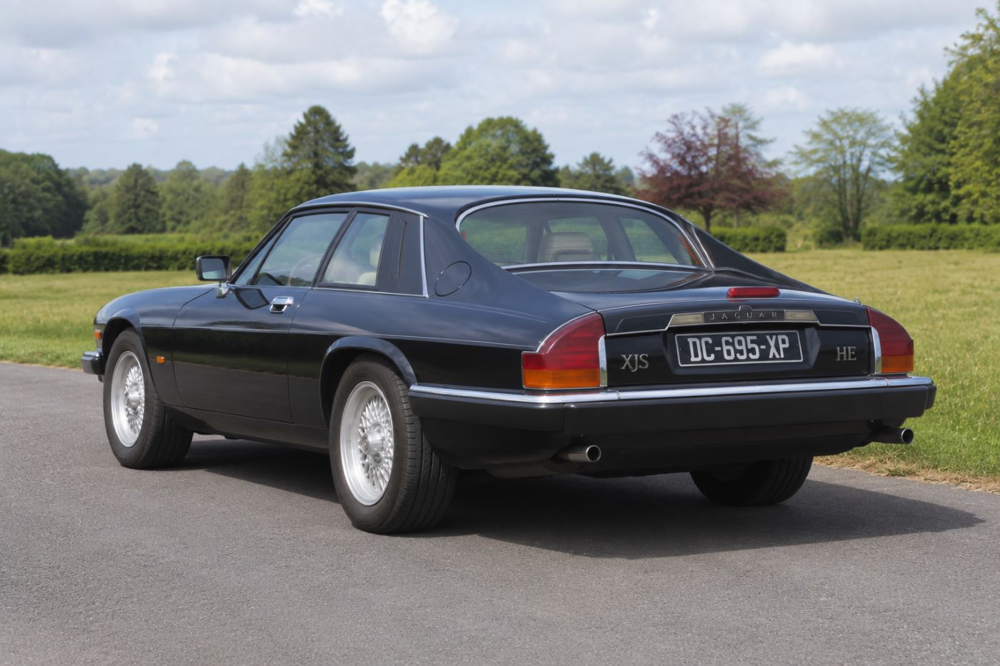 Vue de trois quarts arrière d'une Jaguar XJS mettant en avant les lignes fluides du pavillon, les feux arrière caractéristiques et la poupe élégante qui ont contribué à son identité de GT britannique.