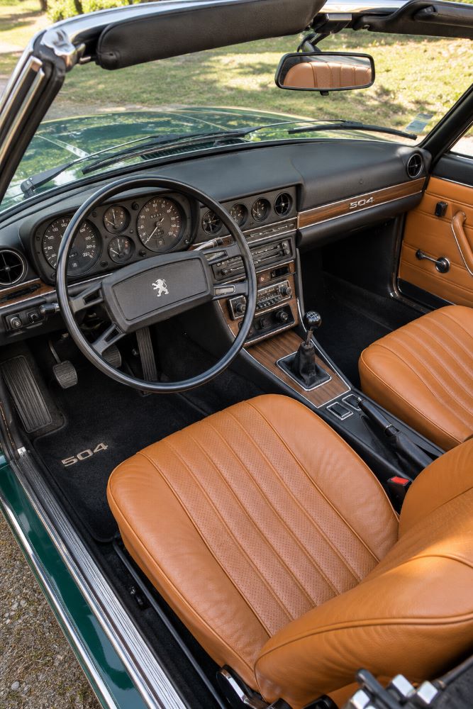 Intérieur d'une Peugeot 504 Cabriolet avec sellerie en cuir et tableau de bord d'origine