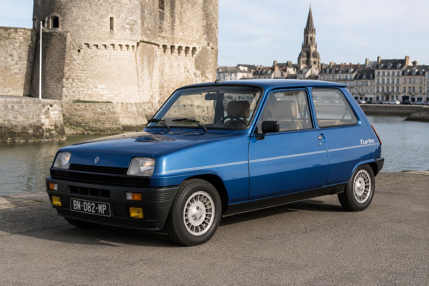 Renault 5 Alpine Turbo photographiée de trois quarts avant, mettant en valeur sa silhouette compacte, ses boucliers spécifiques, ses jantes Alpine et son style sportif typique des années 1980.