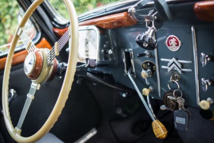 Habitacle authentique d'une Citroën Traction Avant avec tableau de bord d'origine, volant ivoire et instrumentation Jaeger.
