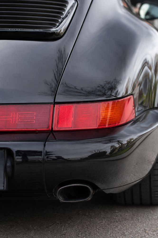 Feu arrière : Gros plan sur le feu arrière droit d'une Porsche 911 (964), détail caractéristique du modèle.