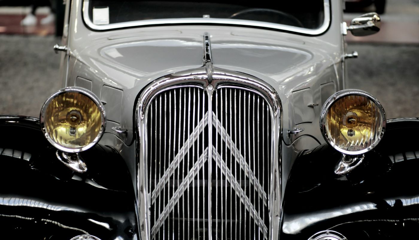 Zoom sur la calandre chromée emblématique de la Citroën Traction Avant, symbole du design automobile français des années 1930.