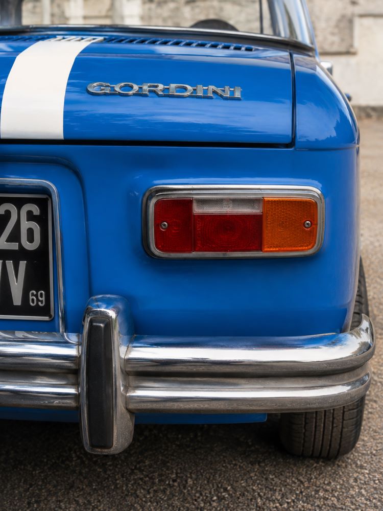 Gros plan sur le feu arrière droit et les détails de carrosserie d'une Renault 8 Gordini restaurée.