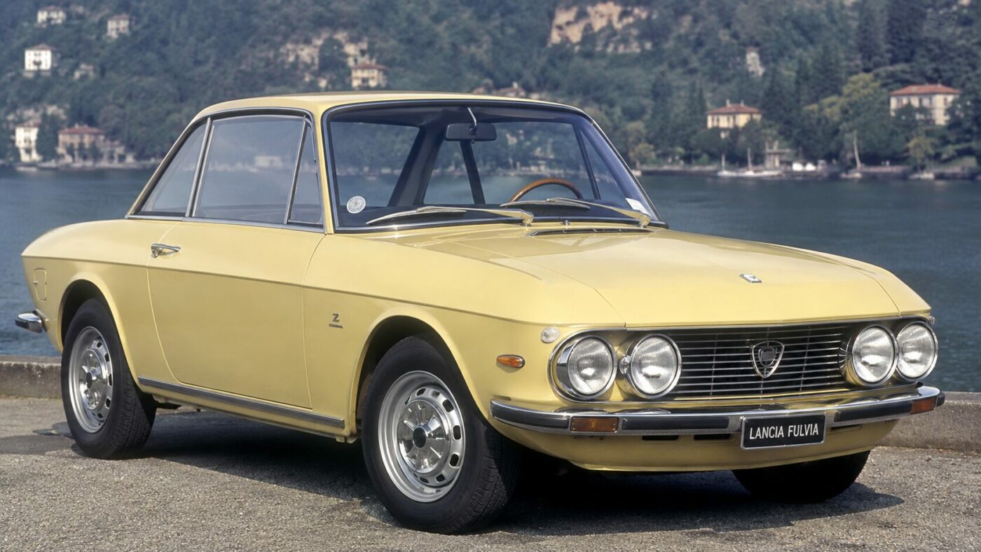 Détails historiques et emblèmes d'époque sur une Lancia Fulvia Coupe soulignant son héritage automobile.