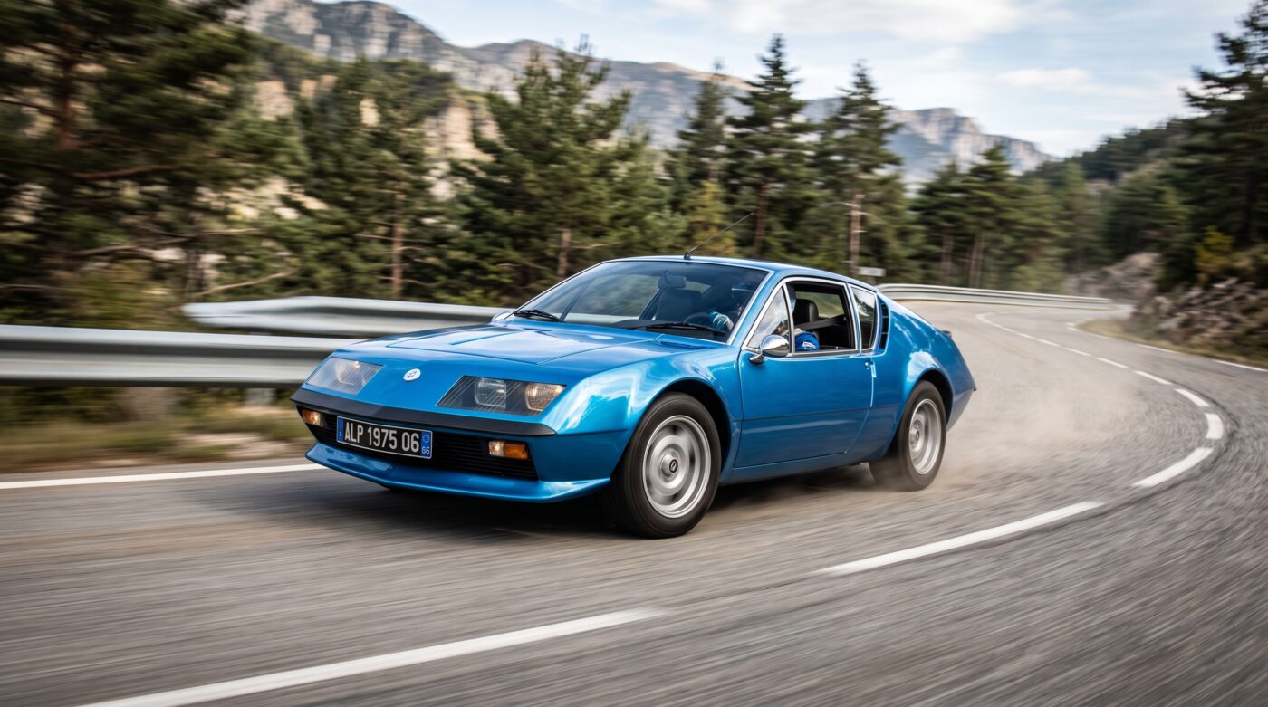 Essai routier d'une Alpine A310 bleue sur route sinueuse, illustrant ses performances sportives.