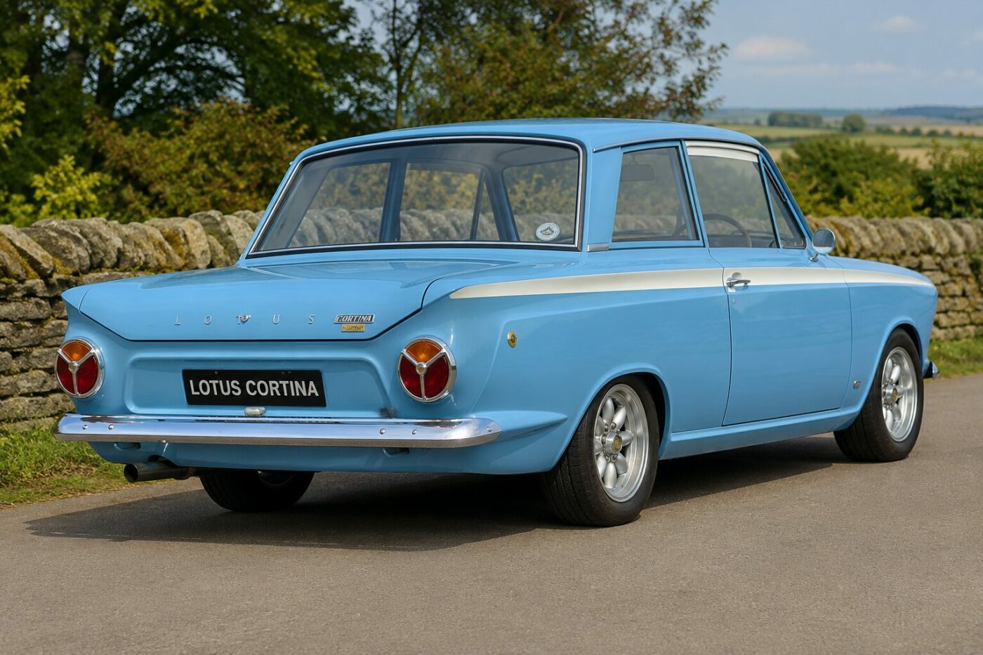 Ford Lotus Cortina 1963 : Vue arrière Vue de trois quarts arrière de la Ford Lotus Cortina 1963 bleu clair, montrant ses lignes authentiques.