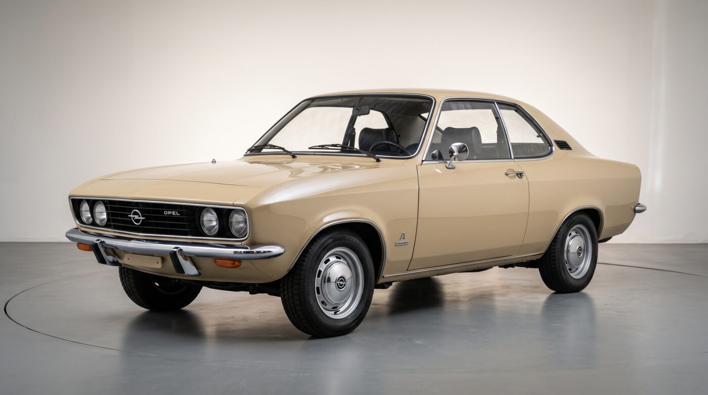 Opel Manta A beige vue de trois quarts avant stationnée dans un studio professionnel avec éclairage naturel.