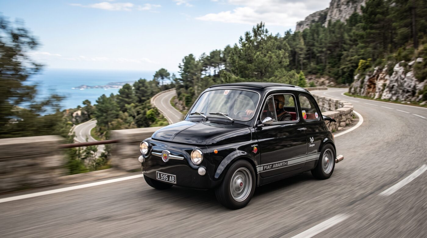Abarth 595 en essai routier Abarth 595 classique noire en plein essai routier sur une route sinueuse panoramique.